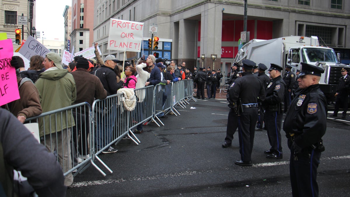 Police stand guard behind barricades keeping protesters well away from the entrance to the Loews Hotel