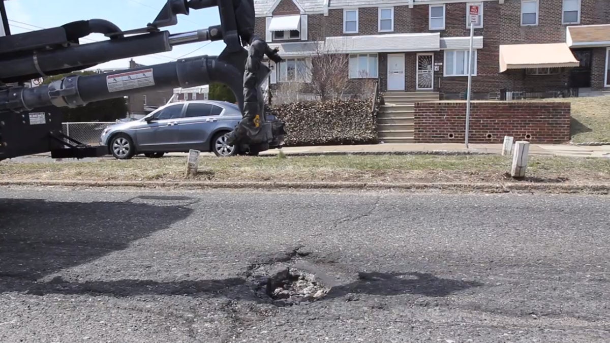 Philadelphia's 'pothole killer' machine uses its extended arm to work its way back and forth