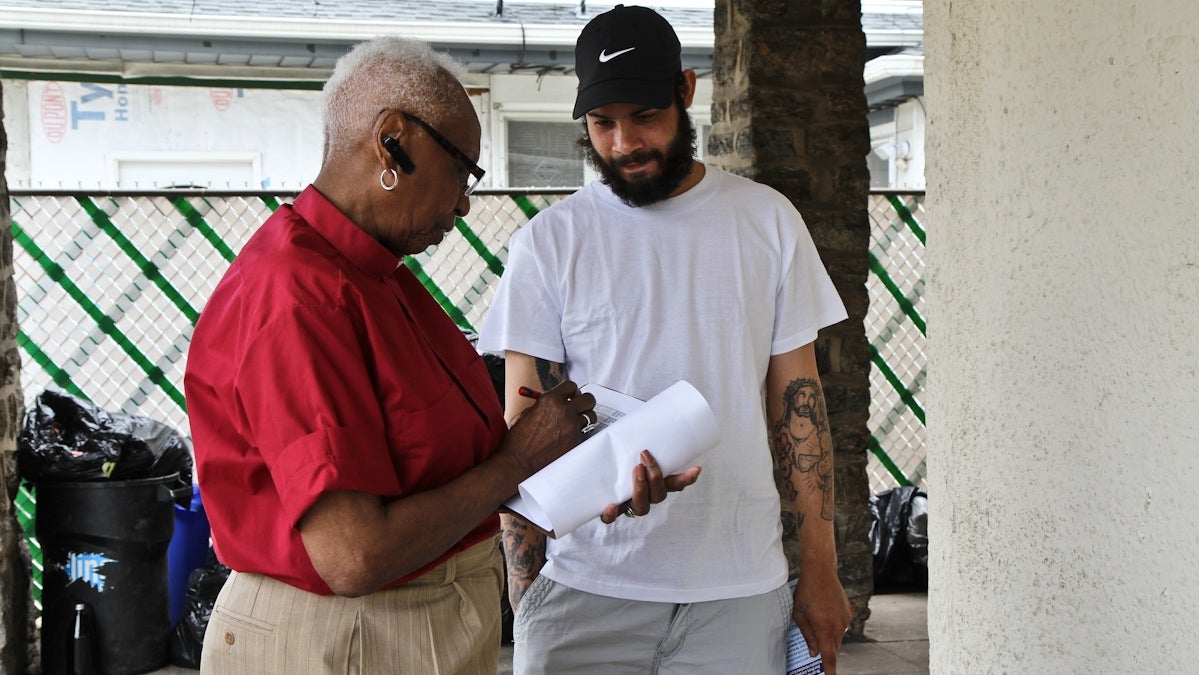  Rev. Bernice Baxter, associate pastor of Harold O. Davis Memorial Baptist Church, asks Gene Carlos Marti if he plans to vote in next week's primary. (Kimberly Paynter/WHYY) 