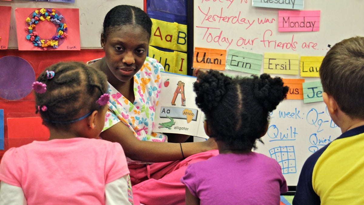 Pre-K teacher Shirell Peaker reads with children at Little Learners Literacy Academy in South Philadelphia. (Emma Lee/WHYY)