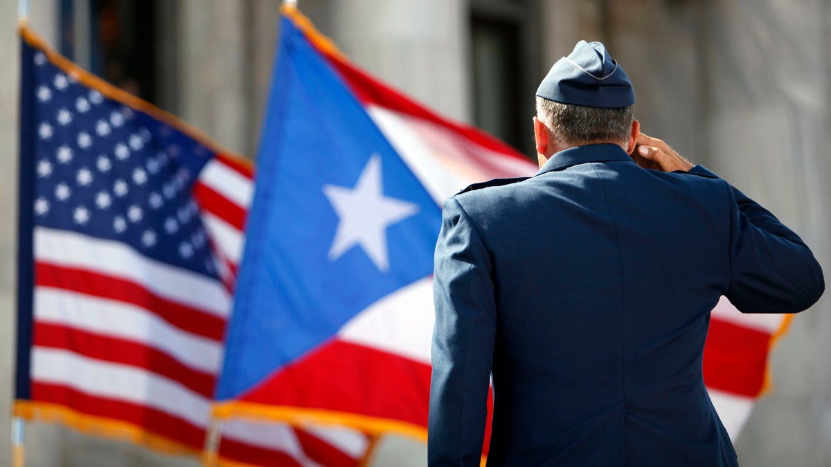  A U.S. Army honor guardsman salutes the Puerto Rican and U.S. flags during the inaugural ceremony for governor-elect Alejandro Garcia Padilla, at the Capitol building in San Juan on Wednesday, Jan. 2, 2013. Puerto Ricans endorsed U.S. statehood for the Caribbean island — and in the same election ousted pro-statehood governor Luis Fortuno. (AP Photo/Ricardo Arduengo) 