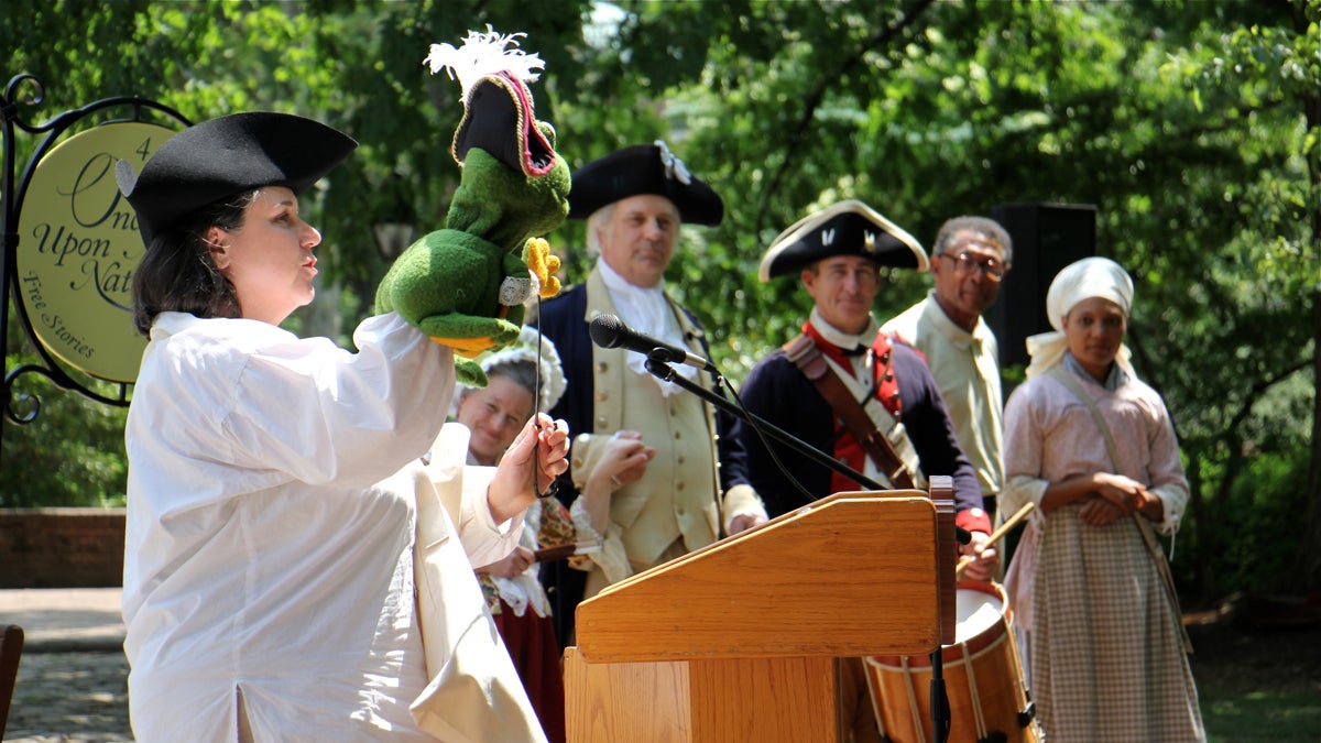 Lorna Howley introduces the Colonial Kids Quest Puppet Show featuring a frog named François. The puppet show and historical re-enactors are part of Philadelphia's campaign to promote its historic district this summer. (Emma Lee/WHYY)