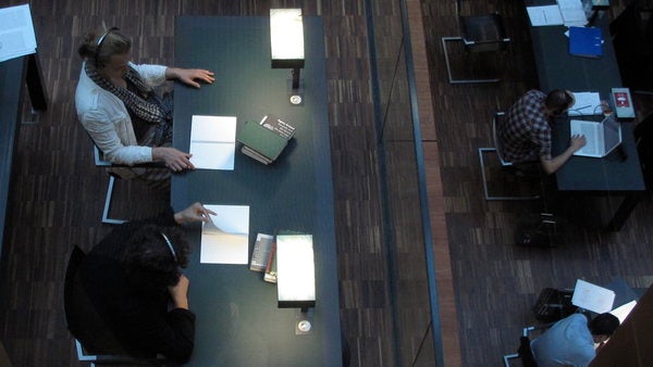  Two audience members listen on headphones as they participate in 