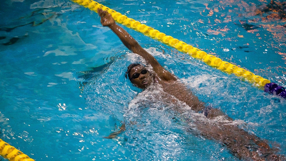 Whitley glides through the water swimming a back stroke in practice. (Brad Larrison/for NewsWorks)