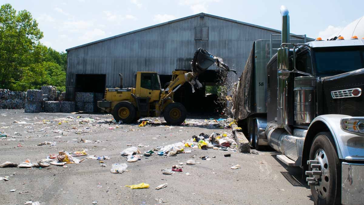 A front loader scoops up  trash that has accumulated at the Omni Recycling Plant in Pitman
