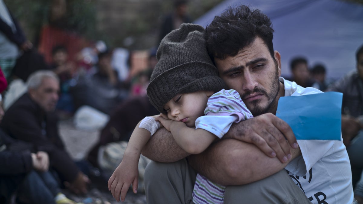  In this Sunday, Oct. 4, 2015 file photo, a Syrian refugee child sleeps in his father's arms while waiting at a resting point to board a bus, after arriving on a dinghy from the Turkish coast to the northeastern Greek island of Lesbos. (AP Photo/Muhammed Muheisen, File) 