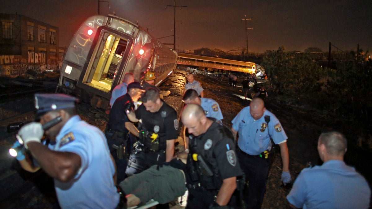 First responders help victims of the Philadelphia train derailment Tuesday night. (AP Photo/ Joseph Kaczmarek)