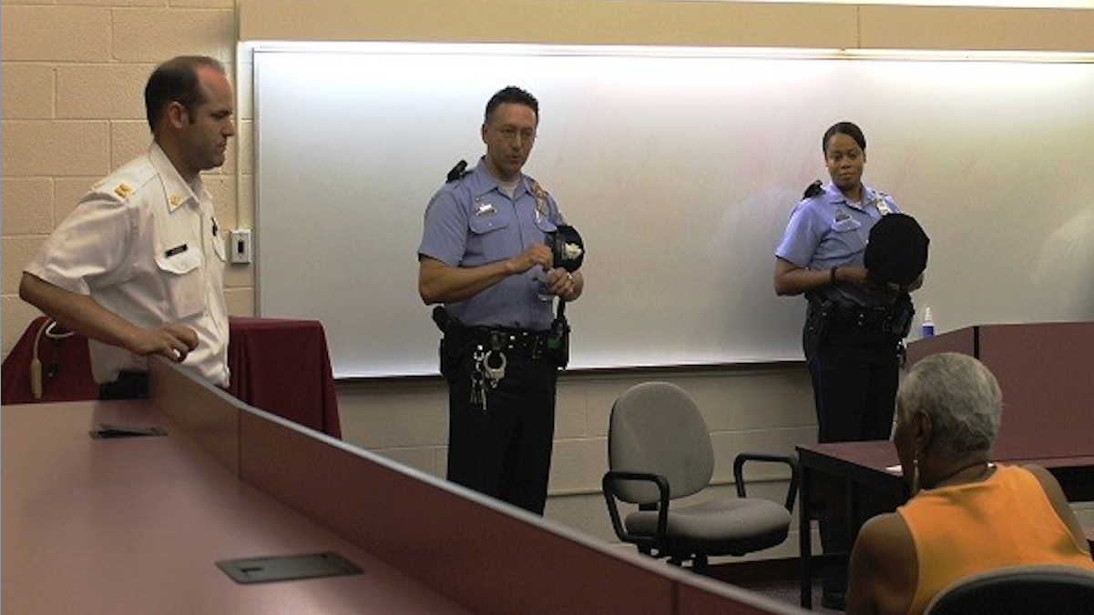  Capt. John Fleming and Officers Thomas Seymour and Kim Harris speak with residents at A PSA-4 meeting in May. (Matthew Grady for NewsWorks) 