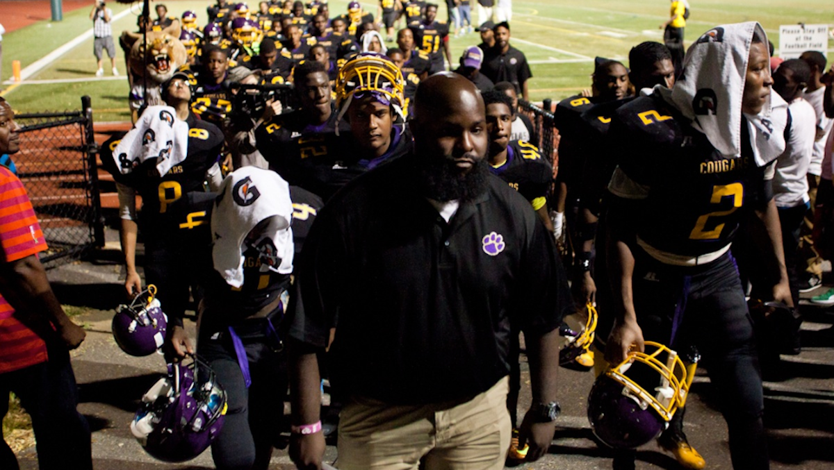  Head Coach Edward Dunn leads his MLK High School Cougars football team off the field after a disappointing 20-16 loss to Mastery Charter on Friday. (Brad Larrison/for NewsWorks) 