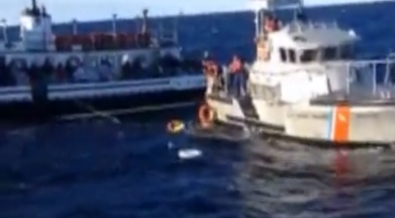 US Coast Guard crew members rescue a man from the ocean off Barnegat Light after the boat he was on capsized Monday morning. (Screenshot from Coast Guard video) 
