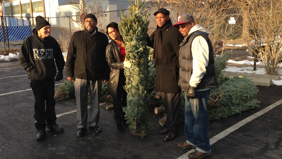  Terrance Smith (far right) said the Christmas-tree giveaway helped out during tough times. (Brian Hickey/WHYY) 
