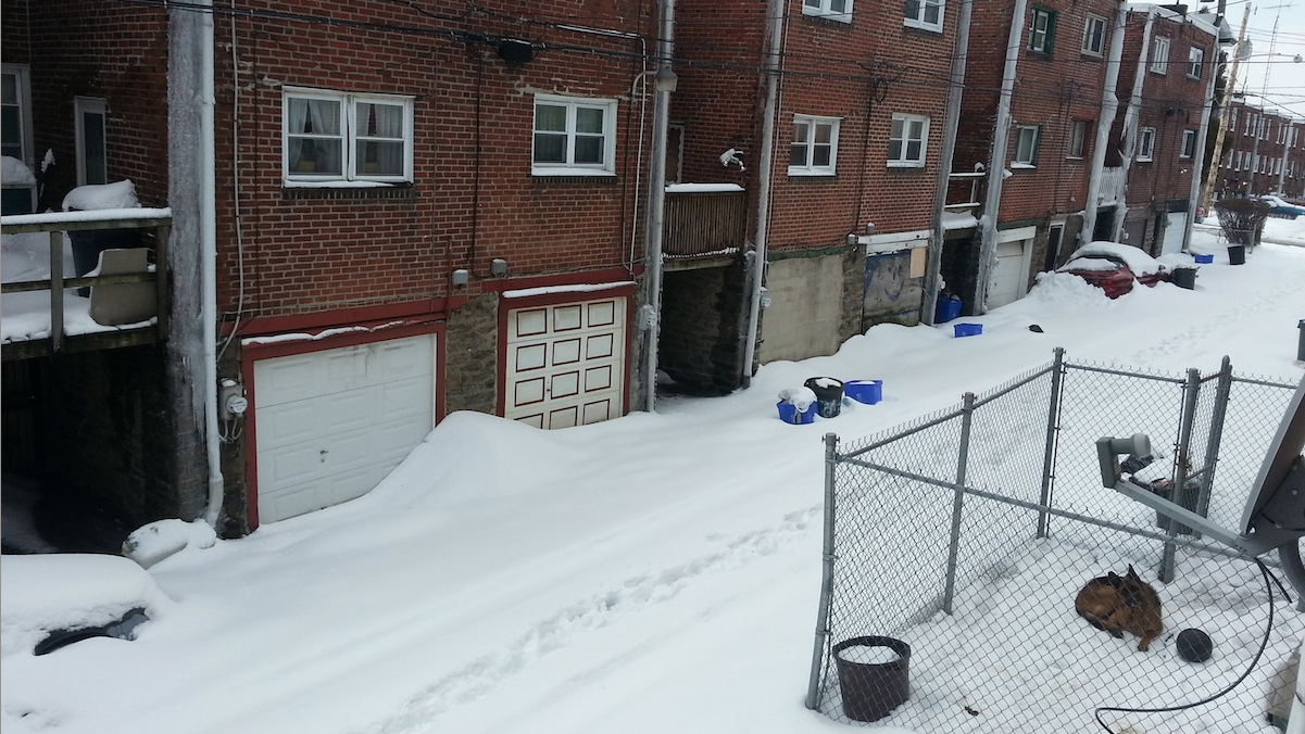  East Mt. Airy resident Joanna Footman has 10 snow-covered trash bags clogging up a back balcony and her alley and she wants them gone now. (Aaron Moselle/WHYY) 