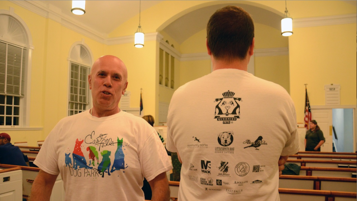  Jim Guaneri (left) and and Joe Silvent show off $10 shirts designed by East Falls Community Council to help raise funds for a proposed dog park. (Jimmy Viola/for NewsWorks)  