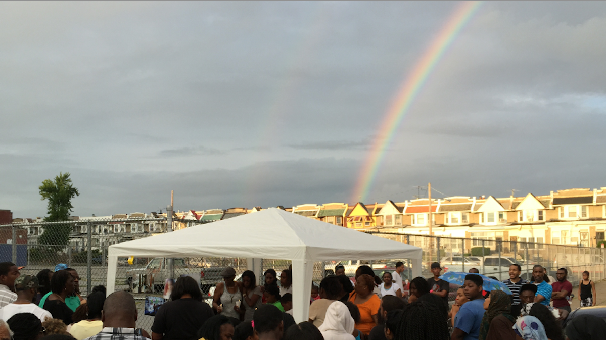  A rainbow in the sky behind Wednesday night's vigil for homicide victim DeeAnna Riddle. (Brian Hickey/WHYY) 