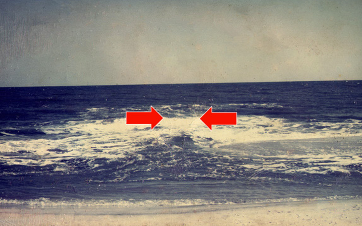  In this NOAA photo, the rip current is surging seaward in the area between the red arrows. 