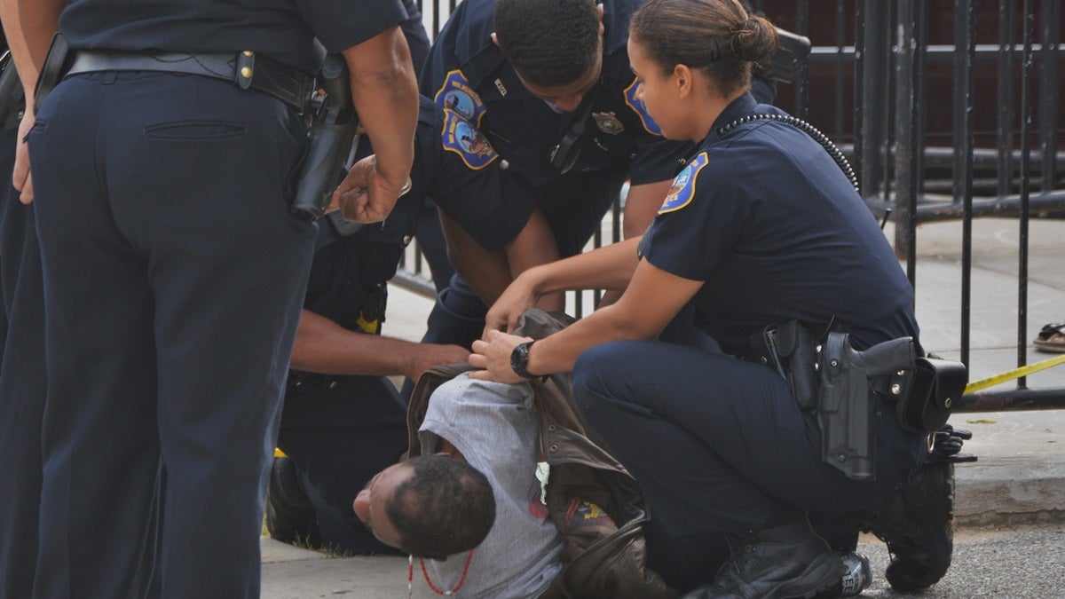  Police handcuff a man accused of pulling out a knife on officers. (John Jankowski/for NewsWorks) 