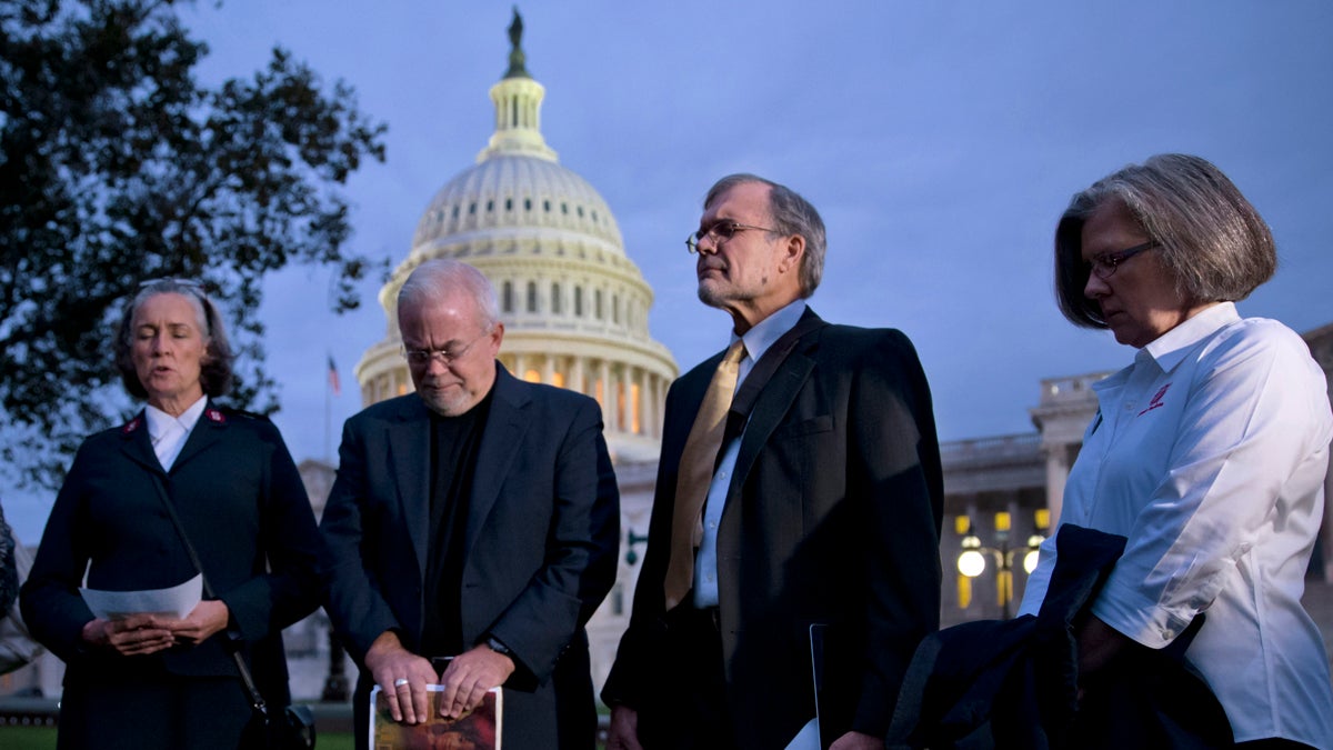  With time growing desperately short for Congress to prevent a threatened Treasury default and stop a partial government shutdown, a group of ministers, the Circle of Protection, pray at dawn at the Capitol to draw attention to lawmakers that political divisiveness hurts the most vulnerable Americans, in Washington, Tuesday, Oct. 15, 2013. From right: Kathy Saile, Gary Cook, Rev. Jim Wallis, and Major Carole Busroe of the Salvation Army. (AP Photo/J. Scott Applewhite) 