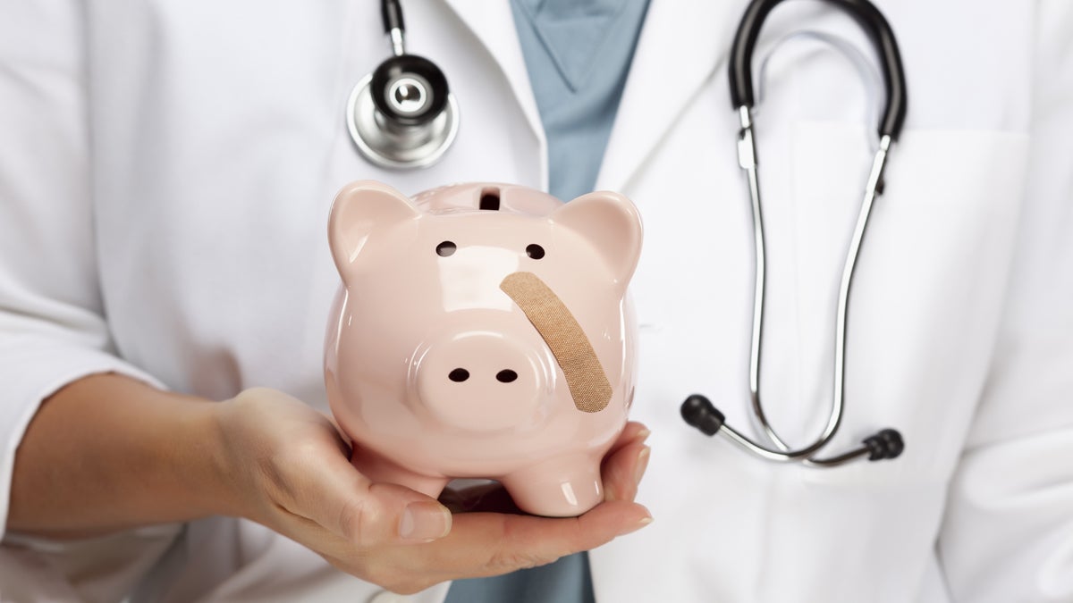  (<a href='http://www.shutterstock.com/pic-125898980/stock-photo-female-doctor-with-stethoscope-holding-piggy-bank-with-bandage-on-face.html'></a> image courtesy of Shutterstock.com) 