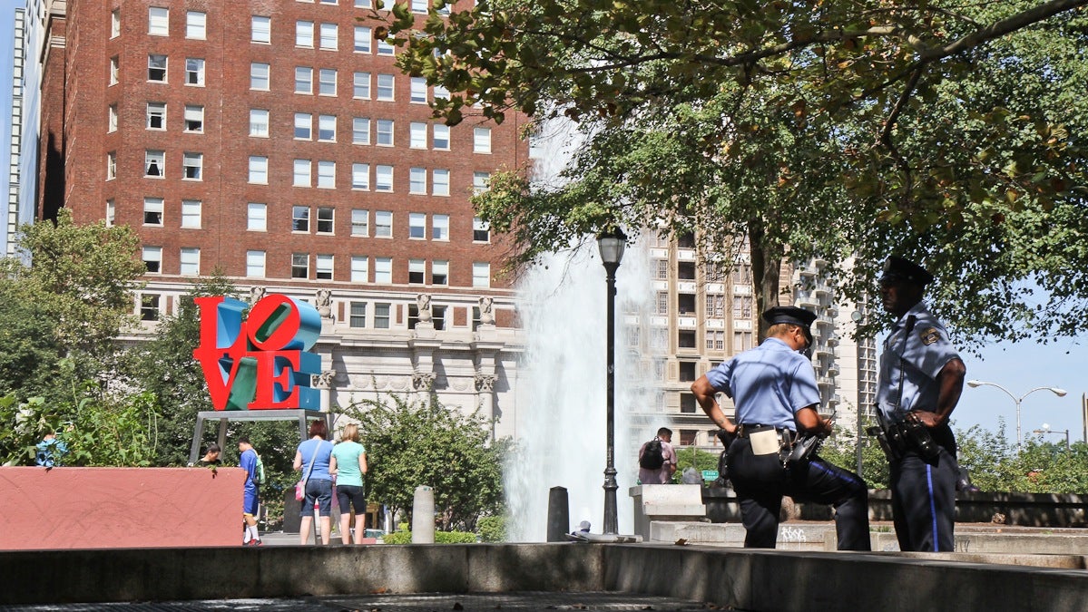  Two Philadelphia police officers keep an eye on activity at Love Park on Monday morning. (Kimberly Paynter/WHYY) 
