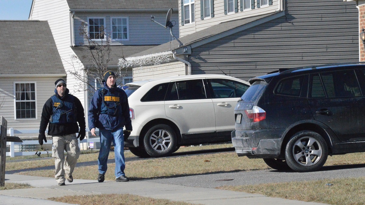  Investigators walk outside the Hamilton's Smyrna house looking for clues. (John Jankowski/WHYY) 
