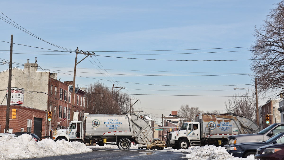  Garbage trucks with plows attached are still cleaning up South Philadelphia Monday morning. (Kimberly Paynter/WHYY) 