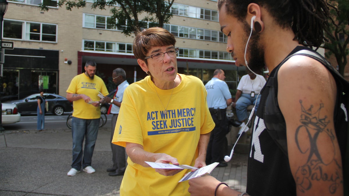 Sister Mary Scullion hands out leaflets in Rittenhouse Square promoting Project HOME's 'Mercy and Justice' campaign. Scullion is working with city officials to accommodate the homeless along the Ben Franklin Parkway during the papal visit. (Emma Lee/WHYY) 
