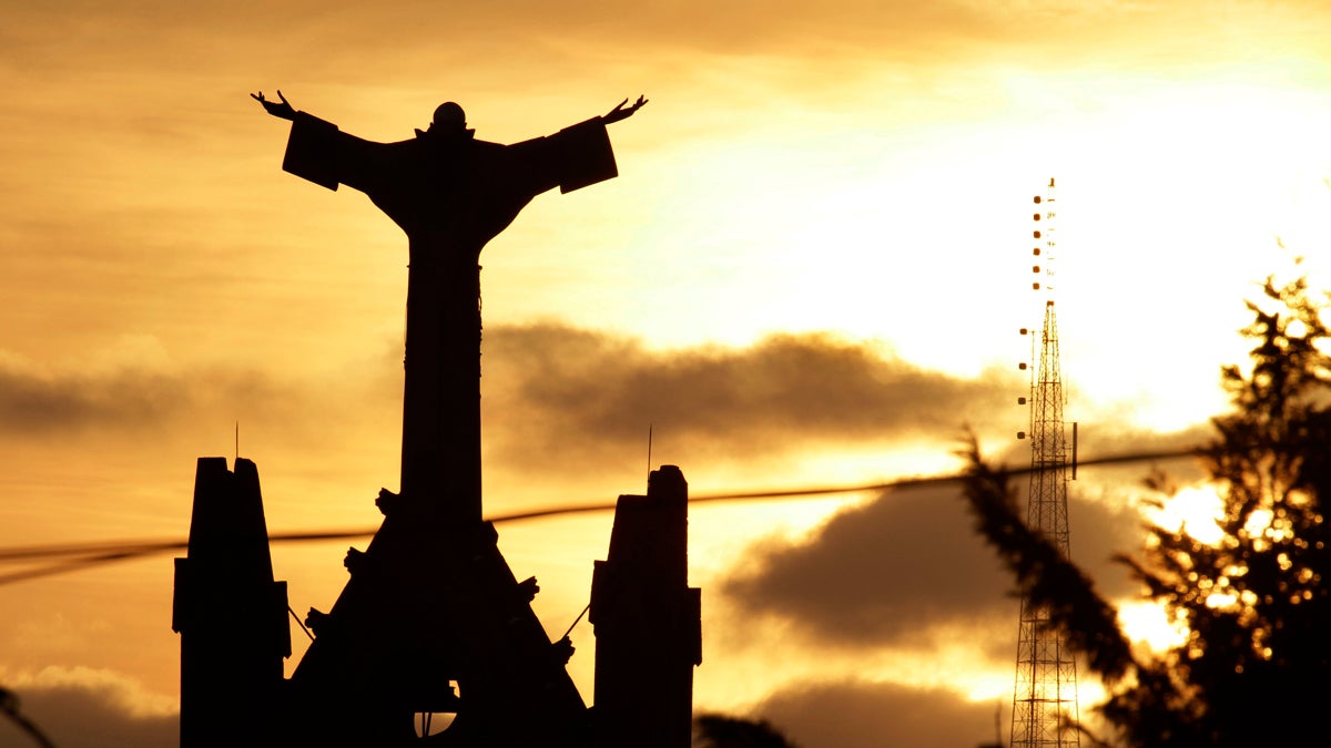 The sun sets behind the steeple of St. Benedict The Moor Catholic Church in Pittsburgh, Pennsylvania.