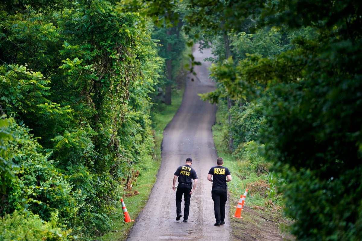 Pennsylvania State Police officers walk up a driveway, Friday, July 14, 2017, in Solebury, Pa. (Matt Rourke/AP Photo)