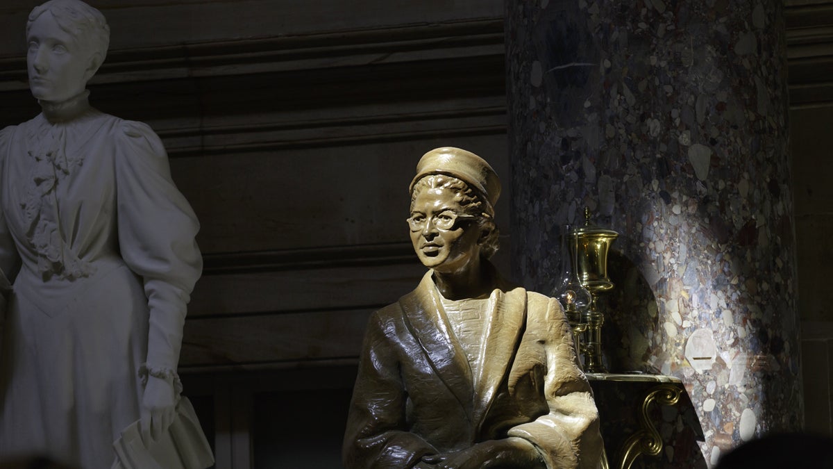  A bronze statue of civil rights icon Rosa Parks is illuminated in a beam of light in Statuary Hall at the U.S. Capitol. A marble statue of temperance pioneer Frances E. Willard is shown in the background. (AP Photo/J. Scott Applewhite, file) 