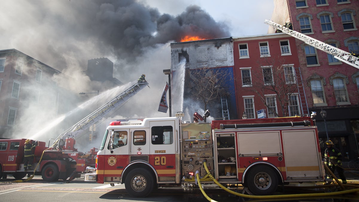  Firefighters try to get a 2-alarm fire under control at the Suit Corner in Center City Philadelphia, Wednesday morning, April 9, 2014.  (Lindsay Lazarski/WHYY) 