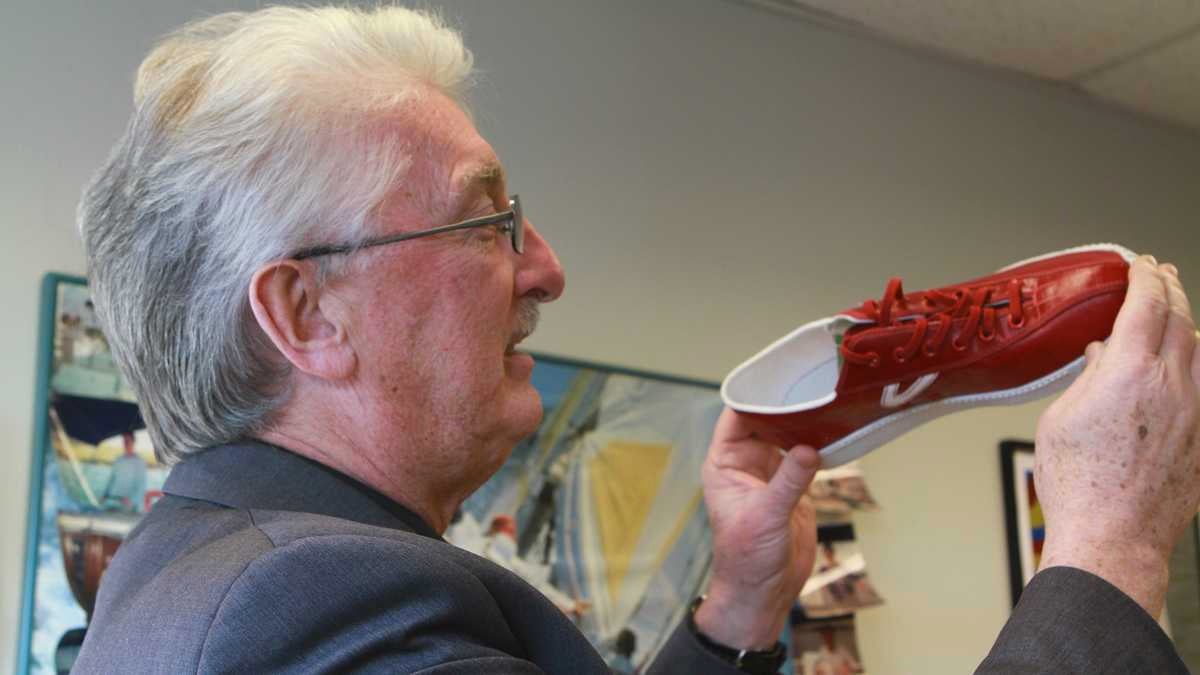 Richard Wool holding a sneaker made of 