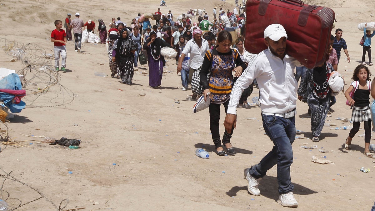  Syrian refugees cross into Iraq at the Peshkhabour border point in Dahuk, 260 miles northwest of Baghdad on Tuesday, Aug. 20. (AP Photo/Hadi Mizban) 