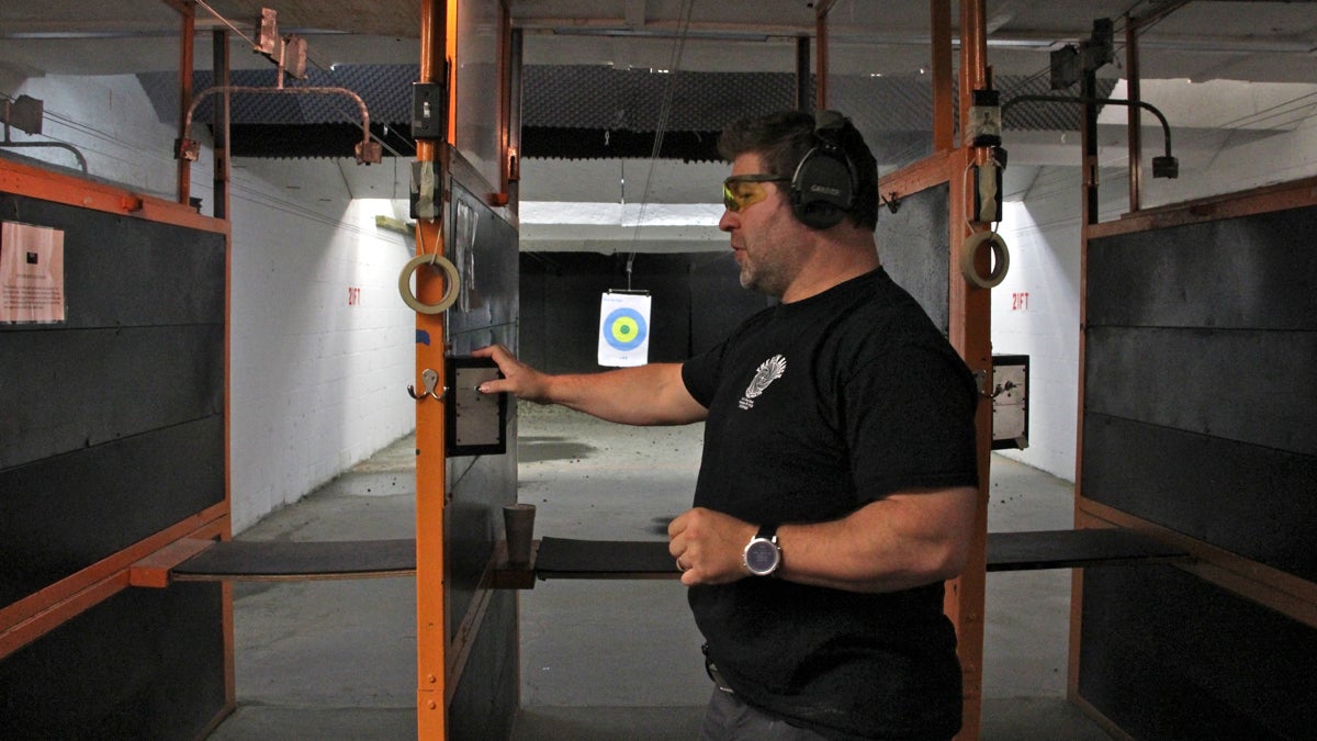 Instructor Chris Garber adjusts a target at The Gun Range at North Percy and Spring Garden streets. (Emma Lee/WHYY)