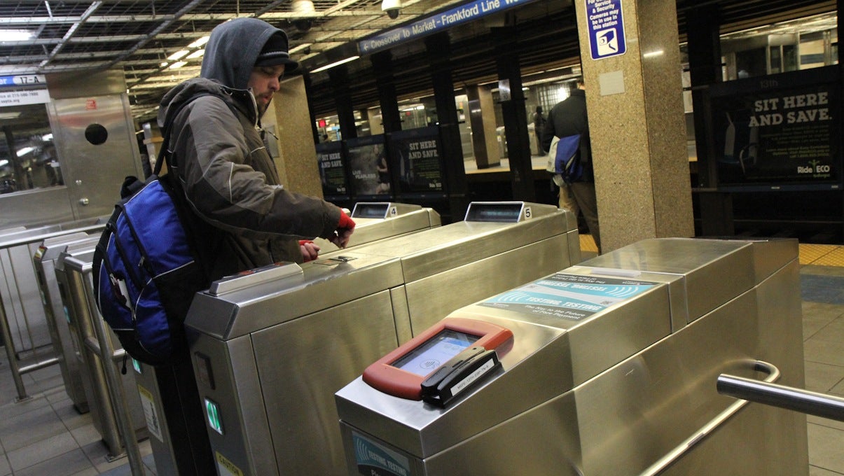  A SEPTA rider inserts a token into an EL turnstile that visitors from New York City of Washington DC would find outdated. (Kimberly Paynter/WHYY) 