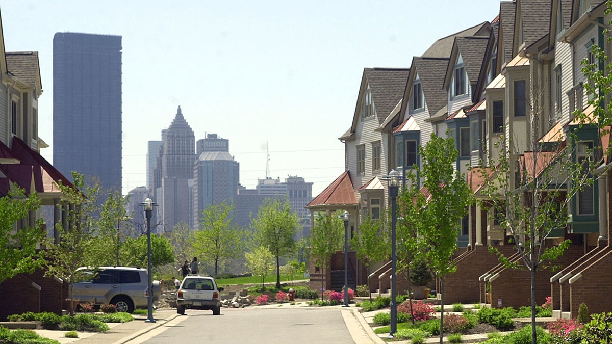  The Pittsburgh skyline rises on the horizon behind townhouses
