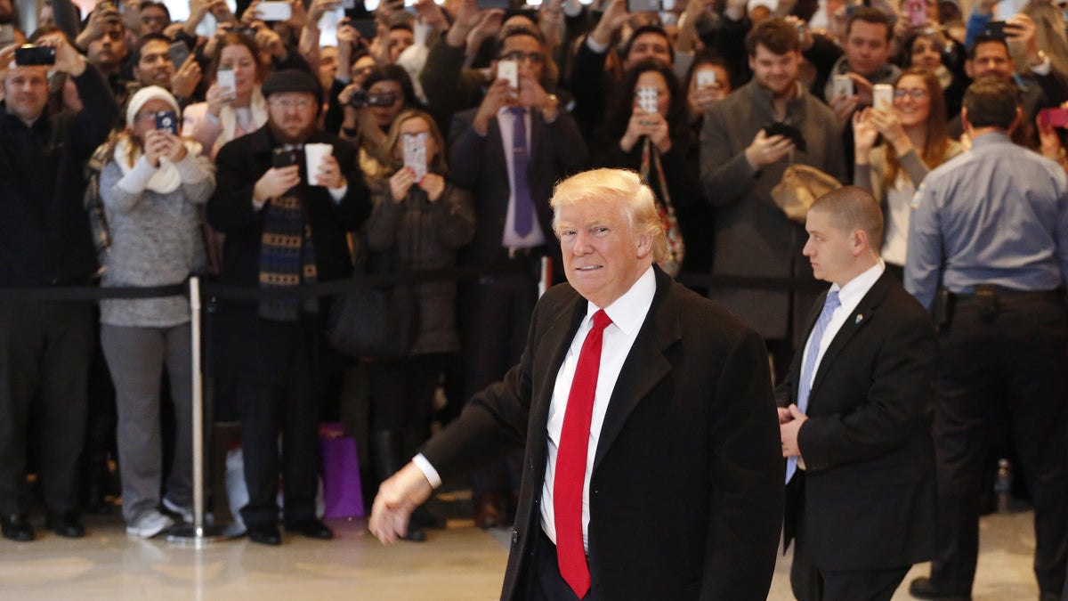 President-elect Donald Trump walks past a crowd as he leaves the New York Times building following a meeting