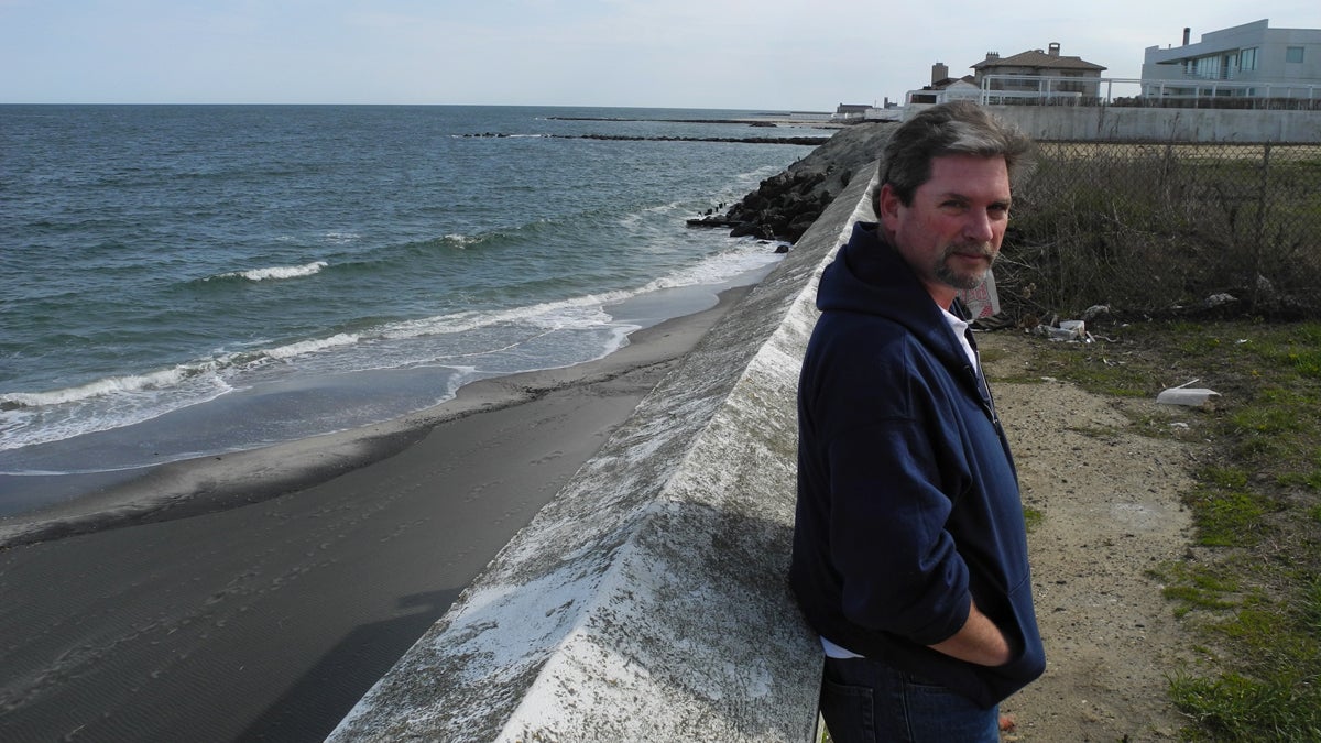  Tim Dillingham, director of the American Littoral Society, leans against a wall on a dead-end street in Deal, N.J. He'd like local officials to tear down the wall and build a set of stairs to the beach below, in order to improve the public's access to the water (Tracey Samuelson/WHYY) 