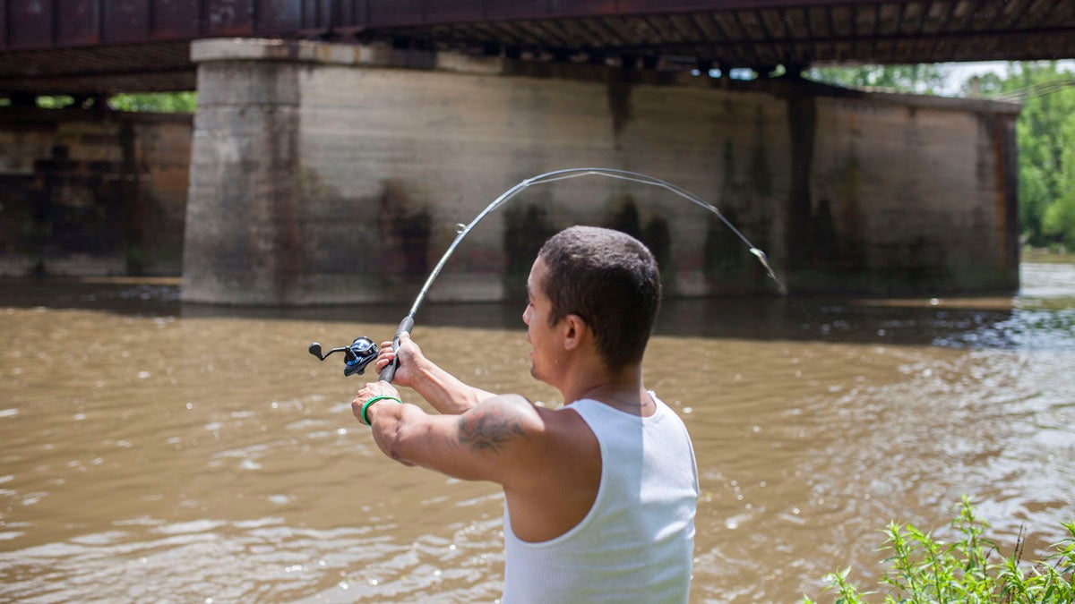 Jeremy Viejegas casts his line into the Schuylkill River in Reading. (Jessica Kourkounis/for WHYY)