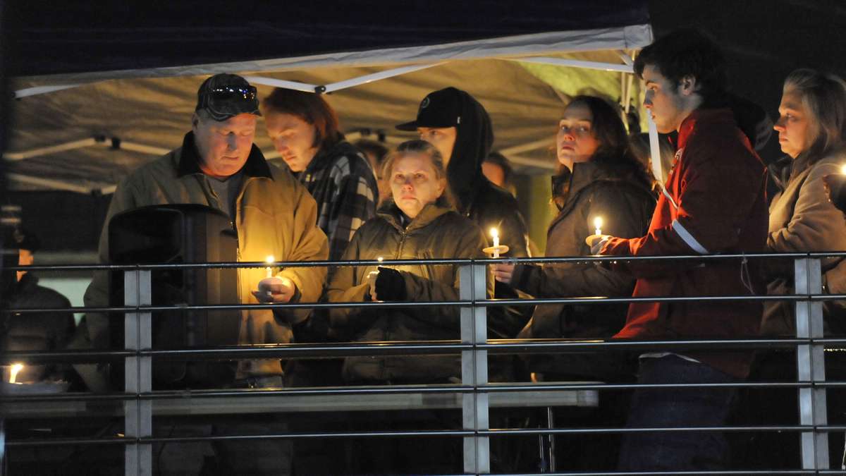  Shane Montgomery's parents, Karen and Kevin Montgomery (left) are joined by friends and family during a candlelight vigil held on the campus of West Chester University last week. (Jonathan Wilson/for NewsWorks) 