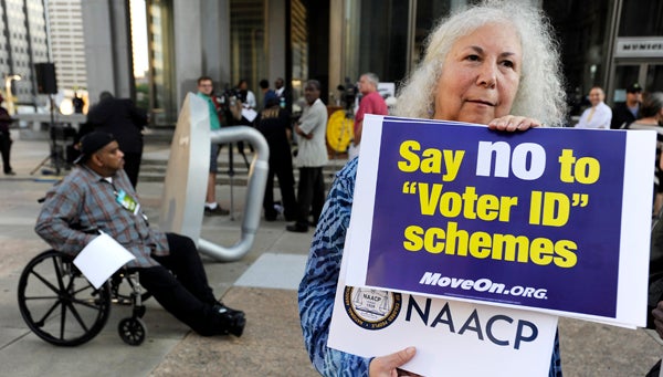  In this September 2012 photo, a protestor holds a sign during the NAACP voter ID rally to demonstrate the opposition of Pennsylvania's voter identification law, which requires each voter to show valid photo identification. (Michael Perez/AP Photo, file) 