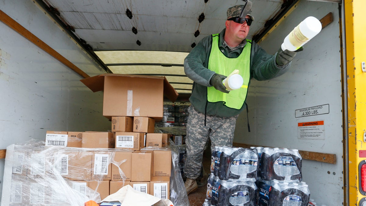 Michigan National Guard Staff Sgt. James Green hands out a water test kit to be distributed to residents