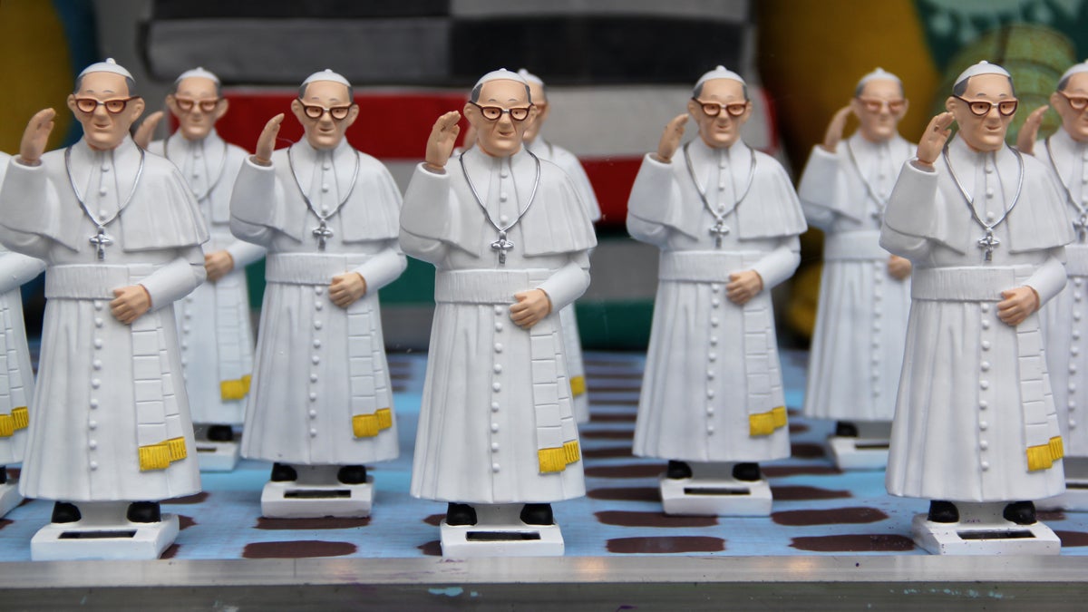  A window display at The Fabric Workshop (1214 Arch Street) features an array of waving Pope Francis statues. (Emma Lee/WHYY) 