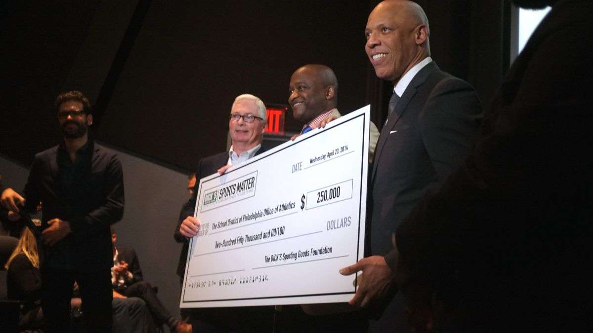  Edward Stack, CEO of DICK's Sporting Goods, presents Superintendent William Hite and MLK Principal William C. Wade with a check for $250,000. (Brad Larrison/for NewsWorks) 