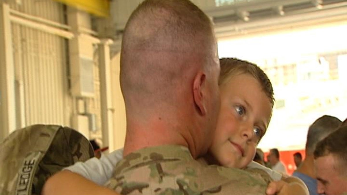  Ryan Ratledge hugs his son after serving with the National Guard in Afghanistan for nearly a year.(Gene Ashley/WHYY) 