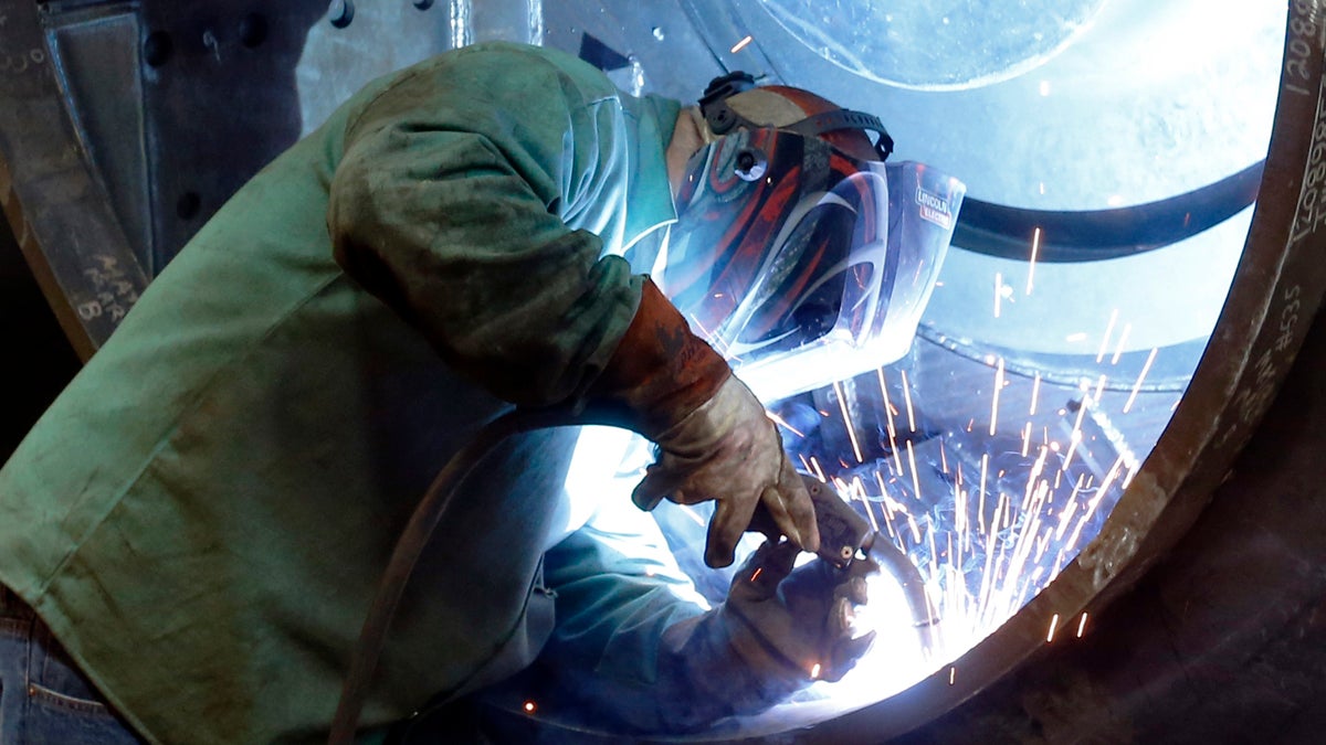 A man welds parts in fans for industrial ventilation systems at the Robinson Fans Inc. plant in Harmony