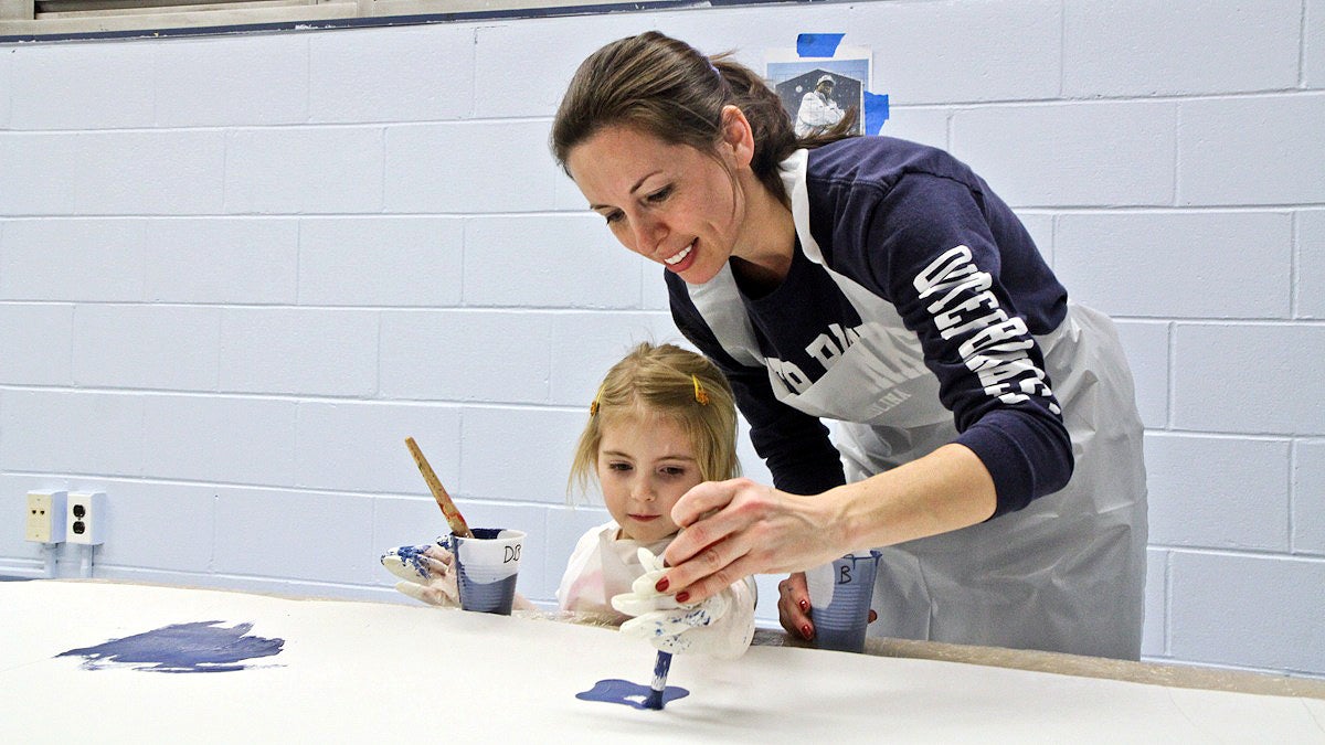  Heather Jordan and her daughter Clare participate in the Mural Arts community paint day in the Mantua section of Philadelphia. (Kimberly Paynter/WHYY) 