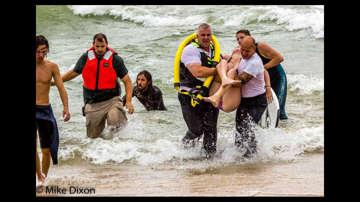 Surfer Zebulon Boeskool (3rd from left) appears exhausted after he and another man saved two distressed swimmers in Lake Michigan on Aug 20