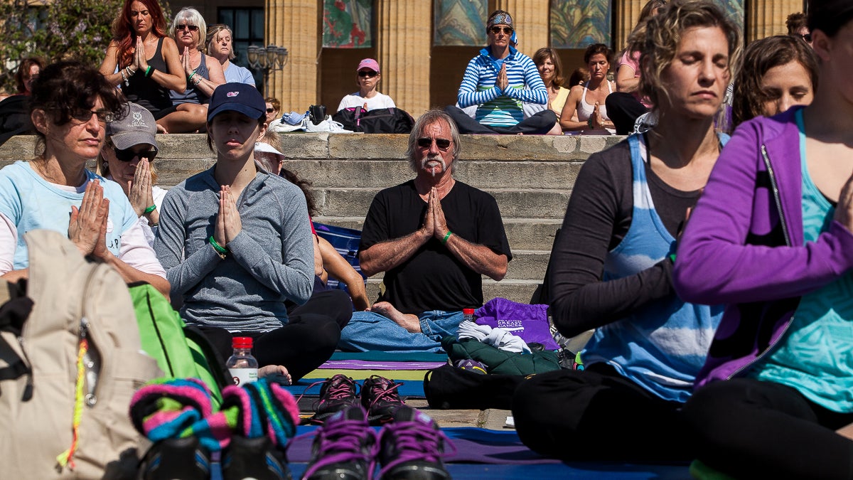 An outdoor yoga class on the steps of the Philadelphia Museum of Art gets underway with a few minutes of reflection. (Brad Larrison/for NewsWorks)