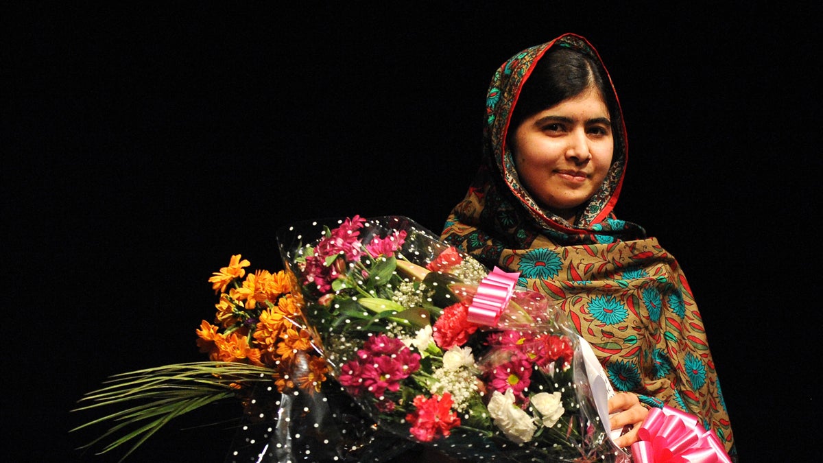 Malala Yousafzai poses with a bouquet after speaking during a media conference at the Library of Birmingham