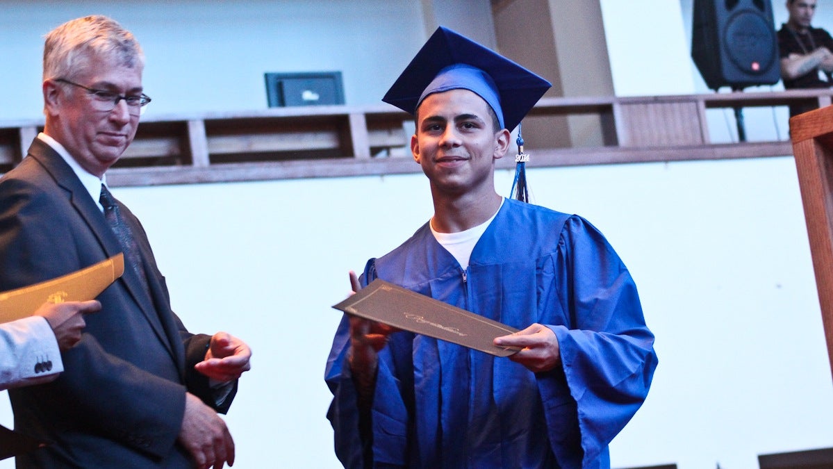 Joel Galarza recieves his diploma at the YouthBuild Philadelphia Charter School Commencement Ceremony for 2014. (Kimberly Paynter/WHYY)